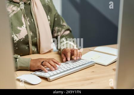 Hands of young Muslim businesswoman in casualwear typing on computer keyboard while developing new software Stock Photo