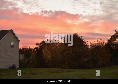 Sycamore, Illinois, USA. An autumn sunset fills clouds with color beyond a modern subdivision. Stock Photo