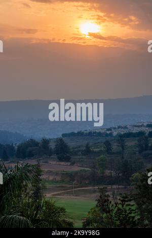 A view of the sun setting over the hills in Kigali, Rwanda Stock Photo