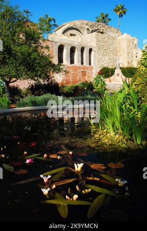 A Koi Pond sits in the center of a courtyard garden at San Juan Capistrano Mission in Orange County, California Stock Photo