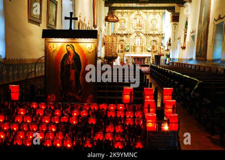 Candles are lit in front of an icon of the Virgin Maryat the Serra chapel, a small church part of the Spanish Mission of San Juan Capistrano Stock Photo