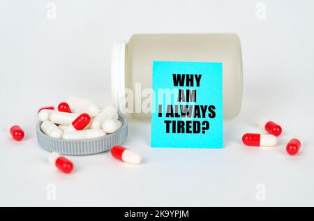 Medical concept. On a gray background, a jar, capsules and a sign with the inscription - Why am i always tired Stock Photo
