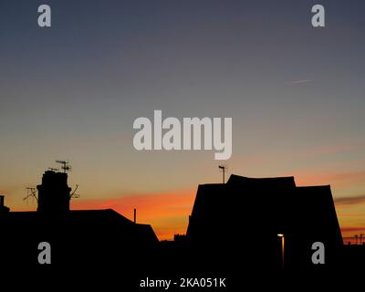 AJAXNETPHOTO.  NOVEMBER, 2021. WORTHING, ENGLAND. - GLOW IN THE SKY -  NORTHERN HEMISPHERE. AUTUMNAL DUSK.  ROOFTOPS SILHOUETTED AGAINST SUNSET OVER WEST WORTHING.PHOTO:JONATHAN EASTLAND/AJAX.  REF:GX8 220509 177 Stock Photo