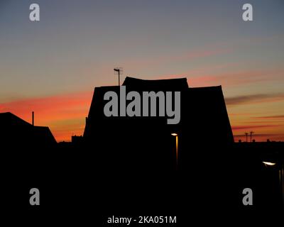 AJAXNETPHOTO.  NOVEMBER, 2021. WORTHING, ENGLAND. - GLOW IN THE SKY -  NORTHERN HEMISPHERE. AUTUMNAL DUSK.  ROOFTOPS SILHOUETTED AGAINST SUNSET OVER WEST WORTHING.PHOTO:JONATHAN EASTLAND/AJAX.  REF:GX8 220509 178 Stock Photo