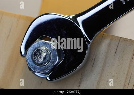 Spanner Tightening Hex Nut To Bolt On Wood Stock Photo