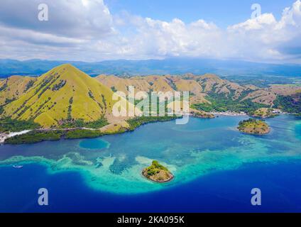 Aerial shot of beautiful blue lagoon at hot summer day with sailing boat. Komodo Island (Komodo National Park), Labuan Bajo, Flores, Indonesia Stock Photo