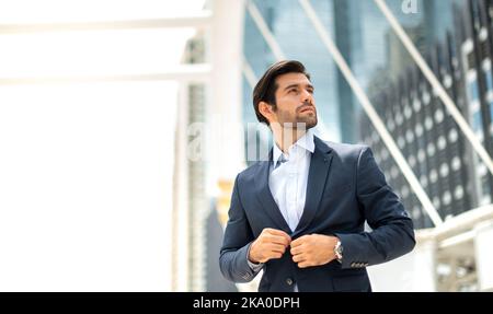 The Portrait of a happy young handsome Caucasian businessman with eyeglasses and wearing a deep blue suit for a professional look. Stock Photo