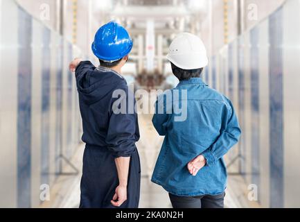A team of construction workers with helmets at work place in a factory Stock Photo