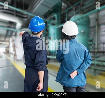 A team of construction workers with helmets at work place in a factory Stock Photo