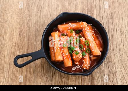 Tteokbokki or Topokki , stir fried rice cake stick, popular Korean street food with spicy gochujang sauce and sesame seed. Stock Photo
