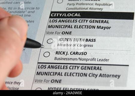 Los Angeles, California / USA - Oct. 30, 2022: A pen is shown about to select a bubble on a mail-in voting ballot for either Karen Bass or Rick Caruso. Stock Photo