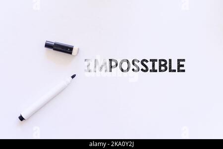 eraser on white paper erase letters "IM" from the word IMPOSSIBLE into POSSIBLE Stock Photo
