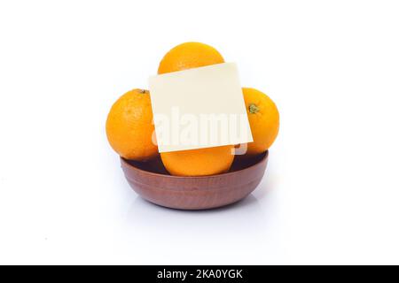 Basket of oranges isolated on white background with yellow sticky note Stock Photo