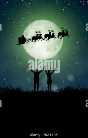 Silhouette of Santa Claus get a move to ride on their reindeer over full moon at night Christmas. Enjoying couple dancing under the full moon. Stock Photo