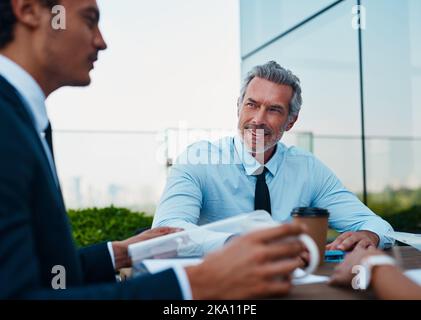The corporates are delegating. corporate businessmen having a meeting outside. Stock Photo