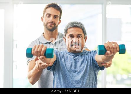 Giving him a helping hand. Cropped portrait of a young male physiotherapist assisting a senior patient in recovery. Stock Photo