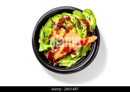 Salad of lettuce, avocado, tempura shrimps, mirin sauce and black sesame in bowl Stock Photo