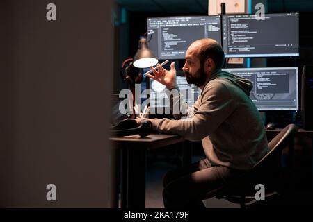 Focused software engineer thinking about source code to develop database online cloud, brainstorming ideas after hours. Being pensive and working on system interface, app programming. Stock Photo