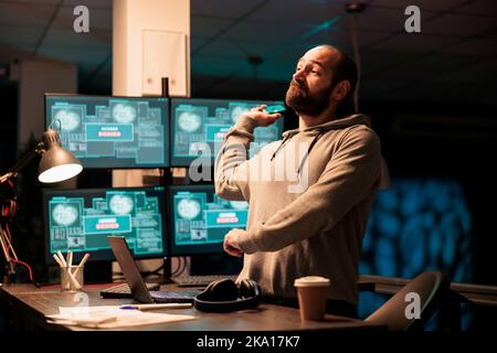 Aggressive male hacker throwing mouse in office, failing to hack computer interface and installing virus on server. Impostor acting angry and trying to steal software information, hacking failure. Stock Photo