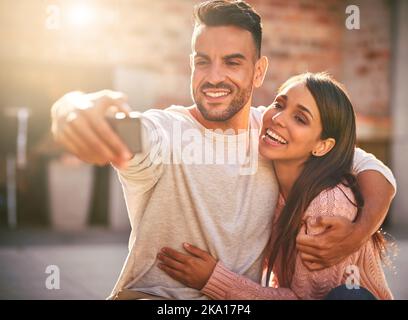 The leading lady in my life. a happy young couple taking selfies together outdoors. Stock Photo