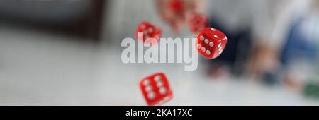 Woman hand throws red dice into air closeup Stock Photo