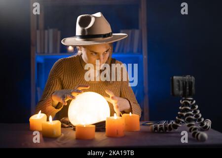 Fortune teller or soothsayer online on smartphone. Using crystal ball on the magic table background. Future reading and divination Stock Photo