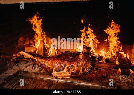 The lamb is cooked entirely on a spit on the fire. Cooking Stock Photo