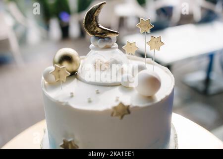 Close-up of beautiful cake for Christening. White cake decorated by stars from sugar. Gold stand Stock Photo