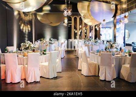 Luxury decor in restaurant. Round table with different elements of decor. Beautiful flowers and table setting Stock Photo