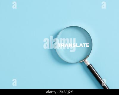 Magnifier with the text translate on blue background. Language translation concept. Stock Photo