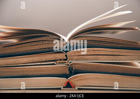 Open old books stacked, close-up on blurred background. Stock Photo