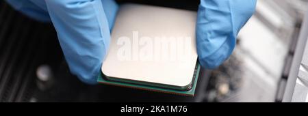 Technician examines microprocessor chip on PC motherboard Stock Photo