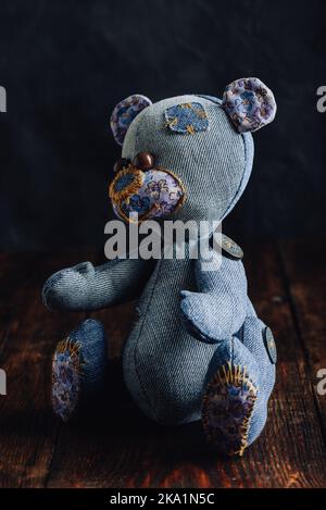 Blue Handmade Stuffed Bear Toy Sitting on Wooden Surface Stock Photo
