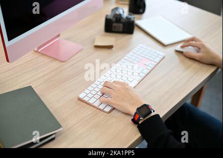 Professional male photographer working at his desk, using computer to adjust his picture on the program. cropped and close-up image Stock Photo