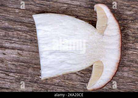 Half of a fresh white mushroom on a wooden background, macro photography Stock Photo