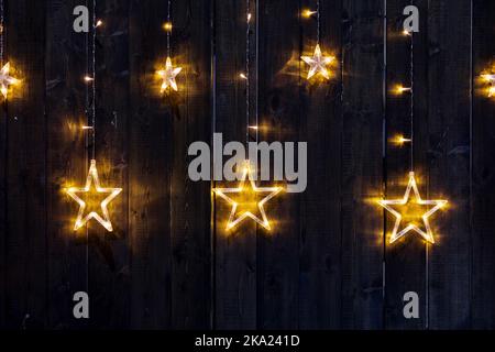 Christmas decoration. star light.  glowing  star lamps on wooden wall Stock Photo