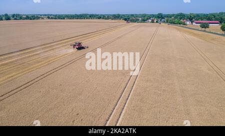 An aerial of a machine harvesting produces at a wheat field Stock Photo ...