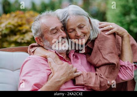 Happy couple relaxing together in their garden. Stock Photo