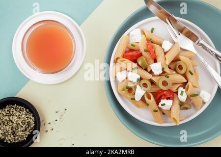 Red lentil penne salad with hempseeds and fruit juice Stock Photo