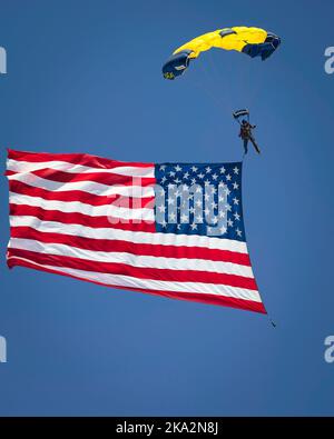 A member of the US Navy Leap Frogs parachute team brings the American flag to the 2022 Miramar Airshow in San Diego, California. Stock Photo