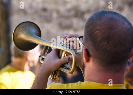 Close back view of a trumpeter performing in a street Stock Photo