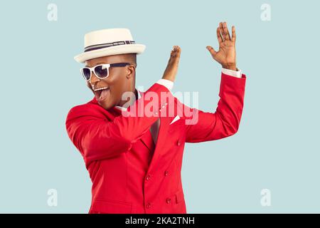 Young African American man red entertainment suit yelling and clapping hands performing dance Stock Photo