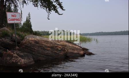 A no camping sign on the shore of Caddy Lake, Manitoba, Whiteshell Provincial Park Stock Photo