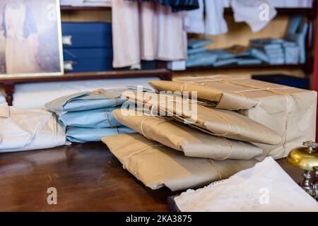 Parcels of clothes wrapped up with brown paper and string in a traditional clothing shop. Stock Photo