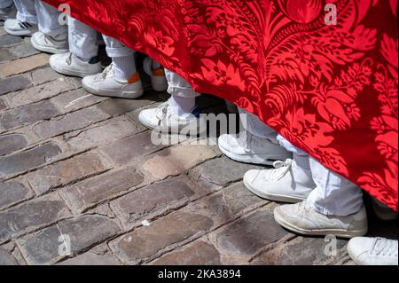 The feet of people carrying a heavy throne  in an Easter Parade during Holy week or semana santa in Cadiz, Spain Stock Photo
