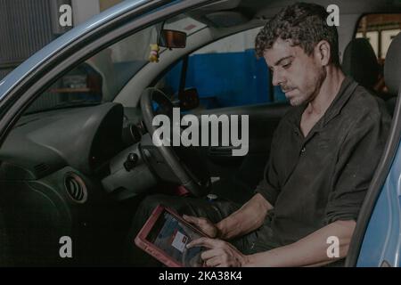 Mechanic using laptop in car Stock Photo