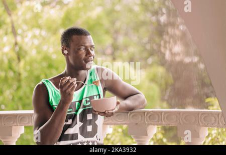 Black man having breakfast on terrace Stock Photo