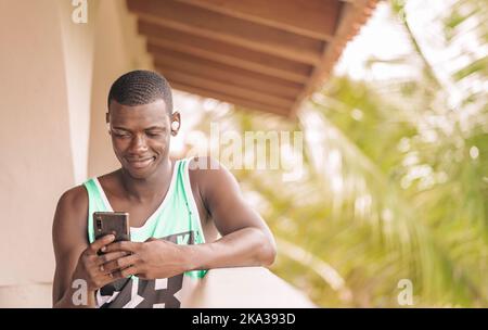 Black man using smartphone on terrace Stock Photo
