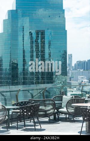 Roof top sky bar table seat with blur skyscraper view background Stock Photo