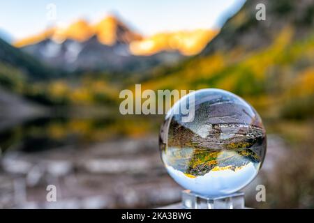 Maroon Bells lake at sunrise with crystal ball glass reflection in Aspen, Colorado with rocky mountain peak and snow in October autumn fall leaf color Stock Photo